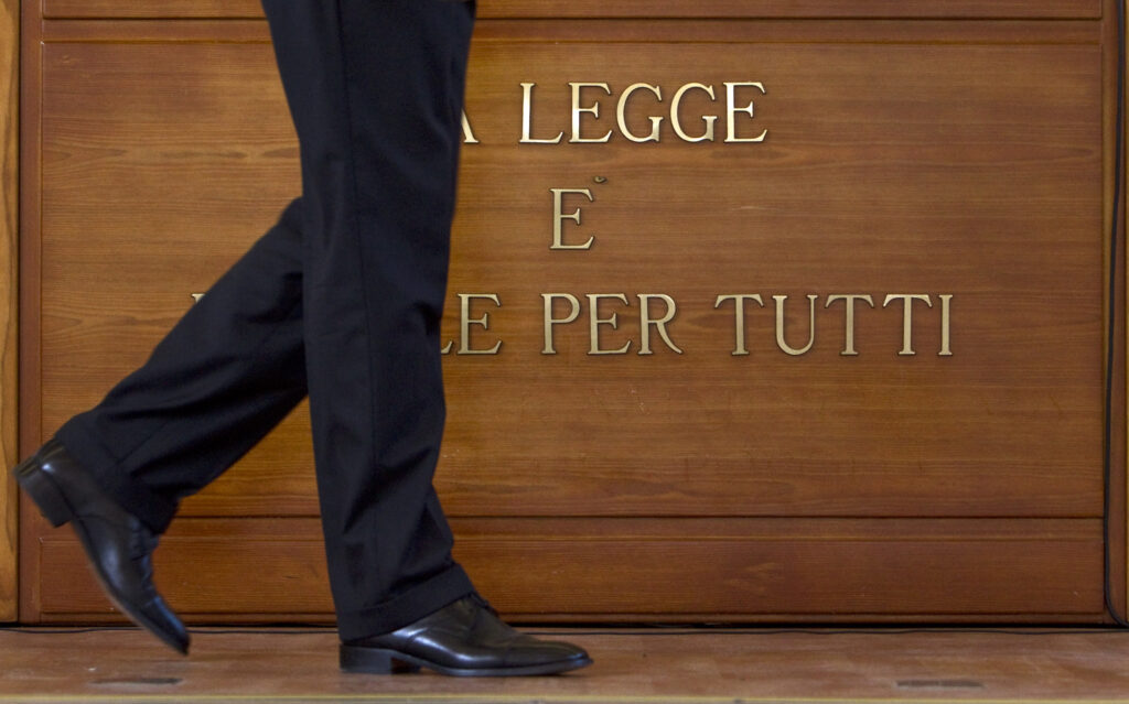 Un uomo passa davanti alla scritta ''La legge e' uguale per tutti'' ANSA/MASSIMO PERCOSSI/GID