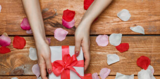 3 regali di San Valentino per stupire la tua donna Valentines Day gift and Female hands on wooden background with petals